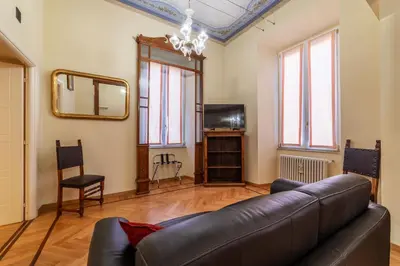 a living room with a leather couch and a mirror at GuestHost - Historic Apartment in Sallustiano in Rome