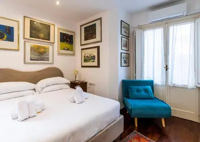 a bedroom with a bed and a blue chair at FCR Rome Apartments Loft Campo de' Fiori - Monserrato in Rome