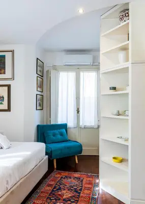 a bedroom with a bed and a blue chair at FCR Rome Apartments Loft Campo de' Fiori - Monserrato in Rome