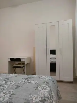 a bedroom with a bed and a desk and cabinets at Casa Flegrei in Rome