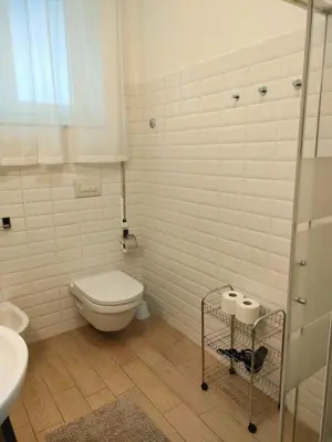 a white bathroom with a toilet and a sink at Casa Flegrei in Rome