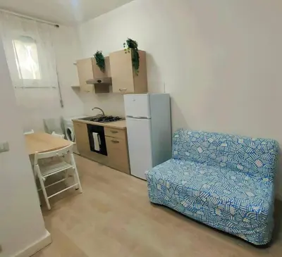 a kitchen with a refrigerator and a chair in a room at Casa Flegrei in Rome