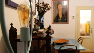 a dining room with a table with a vase of flowers at Cozy artsy apt near the Vatican in Rome