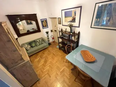 a living room with a table and a couch at Cozy artsy apt near the Vatican in Rome