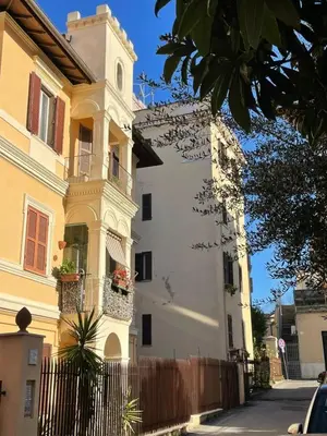 a white building with a fence in front of it at Cozy artsy apt near the Vatican in Rome