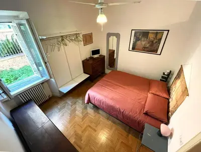 a bedroom with a red bed and a mirror at Cozy artsy apt near the Vatican in Rome