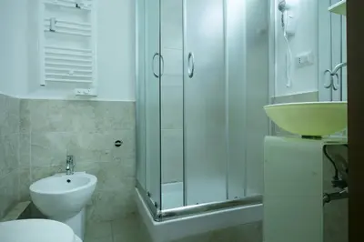 a bathroom with a sink and a toilet and a shower at Lorenzo's Rooms in Vatican in Rome