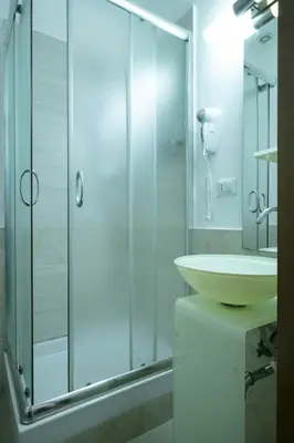 a bathroom with a glass shower and a sink at Lorenzo's Rooms in Vatican in Rome