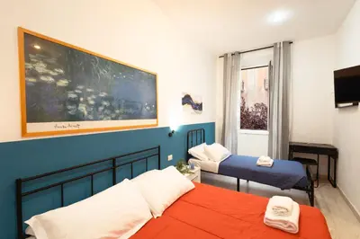 a bedroom with two beds and a large painting on the wall at Lorenzo's Rooms in Vatican in Rome
