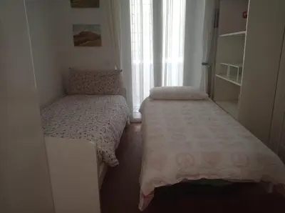 two beds in a small room with a window at Appartamento Annibaliano in Rome