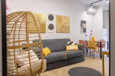 a living room with a gray couch and a rattan ladder at Mabi - Roma San Paolo Centro in Rome