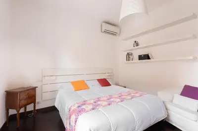 a white bedroom with a bed and a night stand at The Vatican Rest, Elegant Apt Nerby the Basilica in Rome