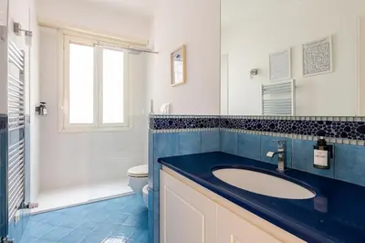 a bathroom with a blue sink and a toilet at Casa Maddalena luxury appartment in Rome