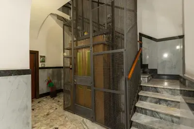 a hallway with a metal door and a staircase at Residenza Margherita in Rome