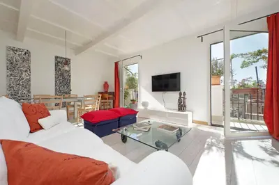a living room with a white couch and a glass table at Colosseo Attico Particolare Terrazza Panoramica in Rome