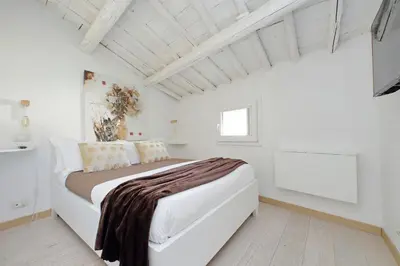 a white bedroom with a large bed in a room at Colosseo Attico Particolare Terrazza Panoramica in Rome