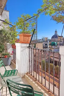 a balcony with two green chairs and a fence at Colosseo Attico Particolare Terrazza Panoramica in Rome