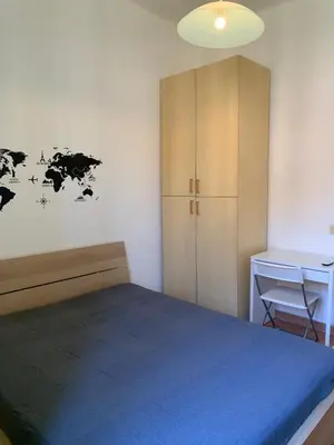 a bedroom with a bed and a cabinet and a desk at Flat nearby Vaticano - Caracciolo 4 in Rome
