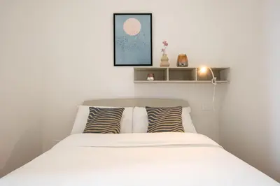 a bedroom with a white bed and a television at Urban Oasis near Termini, Free Parking&Balcony, int10 in Rome