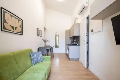 a living room with a green couch and a kitchen at Urban Oasis near Termini, Free Parking&Balcony, int10 in Rome