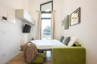 a bedroom with a bed and a green chair at Urban Oasis near Termini, Free Parking&Balcony, int10 in Rome