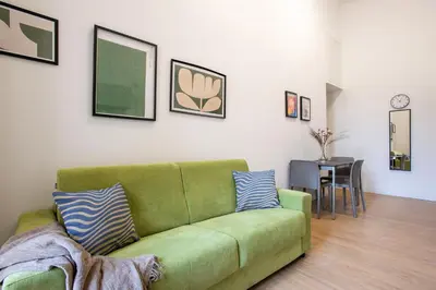 a green couch in a living room with a table at Urban Oasis near Termini, Free Parking&Balcony, int10 in Rome