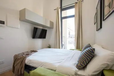 a bedroom with a bed and a tv and a window at Urban Oasis near Termini, Free Parking&Balcony, int10 in Rome