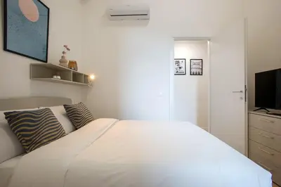 a bedroom with a white bed and a television at Urban Oasis near Termini, Free Parking&Balcony, int10 in Rome