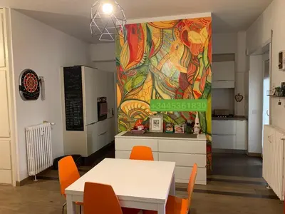 a kitchen with a table and orange chairs and a wall at Il CIGNO in Rome