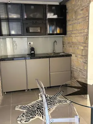 a kitchen with a glass table and a chair at Colosseum loft in Rome