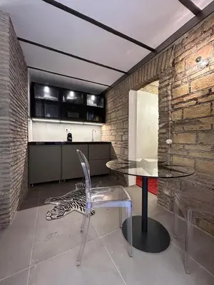 a kitchen with a glass table and a chair at Colosseum loft in Rome