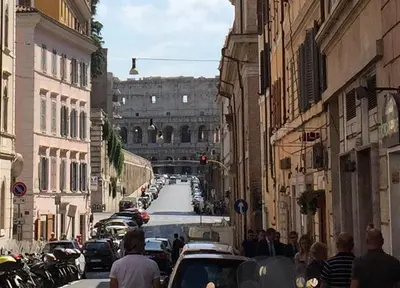 a group of people walking down a busy city street at Colosseum loft in Rome