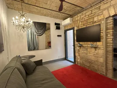 a living room with a couch and a tv on a brick wall at Colosseum loft in Rome
