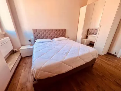 a bedroom with a large bed with a wooden floor at Fast Re Apartment in Rome