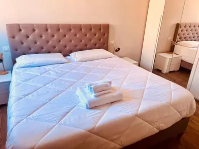 a large white bed with two towels on it at Fast Re Apartment in Rome