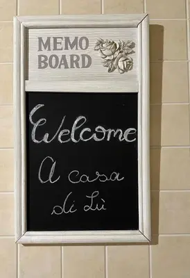 a chalkboard sign that says meno board welcome a cafe at it at A casa di Lù in Rome