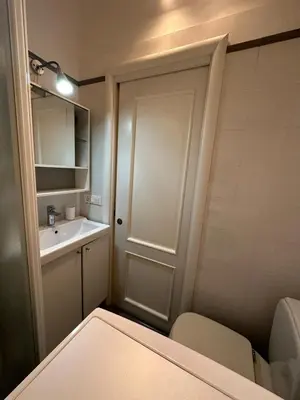 a bathroom with a toilet and a sink and a door at A casa di Lù in Rome