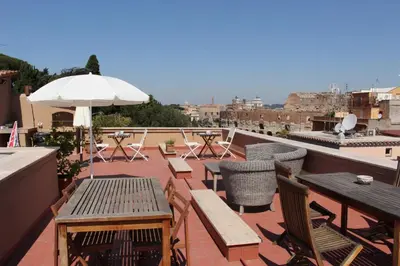 a patio with tables and chairs and an umbrella at Hexa in Rome