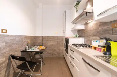 a kitchen with white appliances and a small table at Gemelli Apartment in Rome