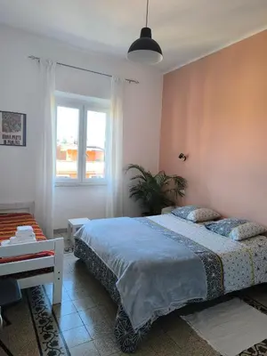 a bedroom with a bed and a table and a window at Cozy Room in Rome