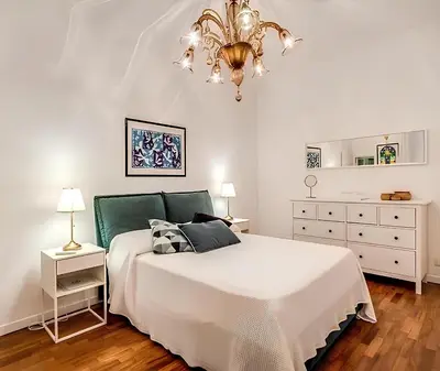 a bedroom with a white bed and a chandelier at Casa Roma in Rome