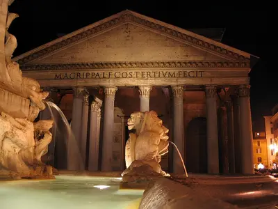 a statue in front of a building at night at Casa Roma in Rome