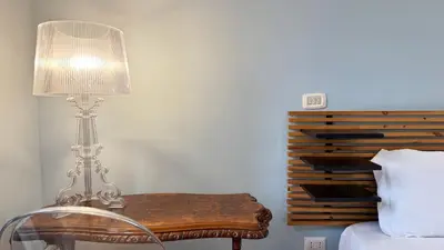 a lamp sitting on a table next to a bed at Domus Leonis in Rome