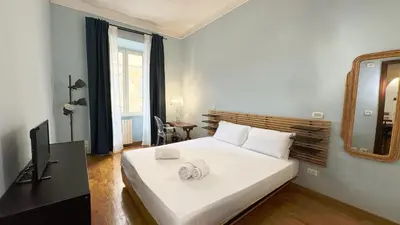 a bedroom with a large white bed and a mirror at Domus Leonis in Rome