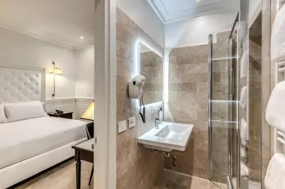 a hotel room with a bed and a sink at ACA Hotel Viminale in Rome