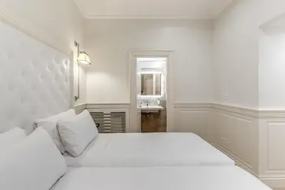 a white bedroom with a bed and a sink at ACA Hotel Viminale in Rome
