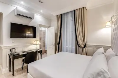 a hotel room with a bed and a desk at ACA Hotel Viminale in Rome