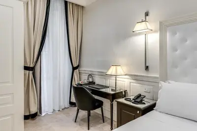 a hotel room with a desk and a bed at ACA Hotel Viminale in Rome