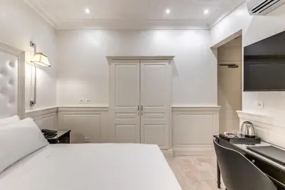 a white room with a bed and a kitchen at ACA Hotel Viminale in Rome