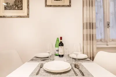 a dining room table with white plates and wine glasses at Vatican Chic House II in Rome